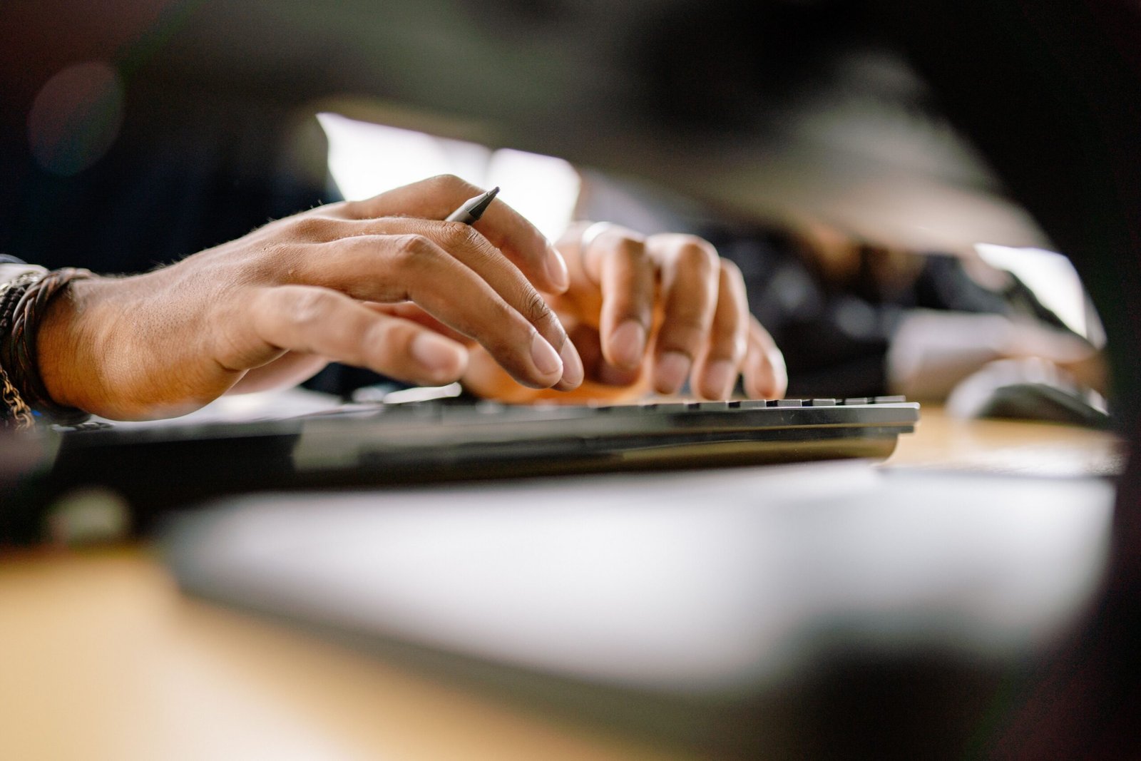 A detailed view of a person typing on a keyboard, emphasizing productivity and office work.
